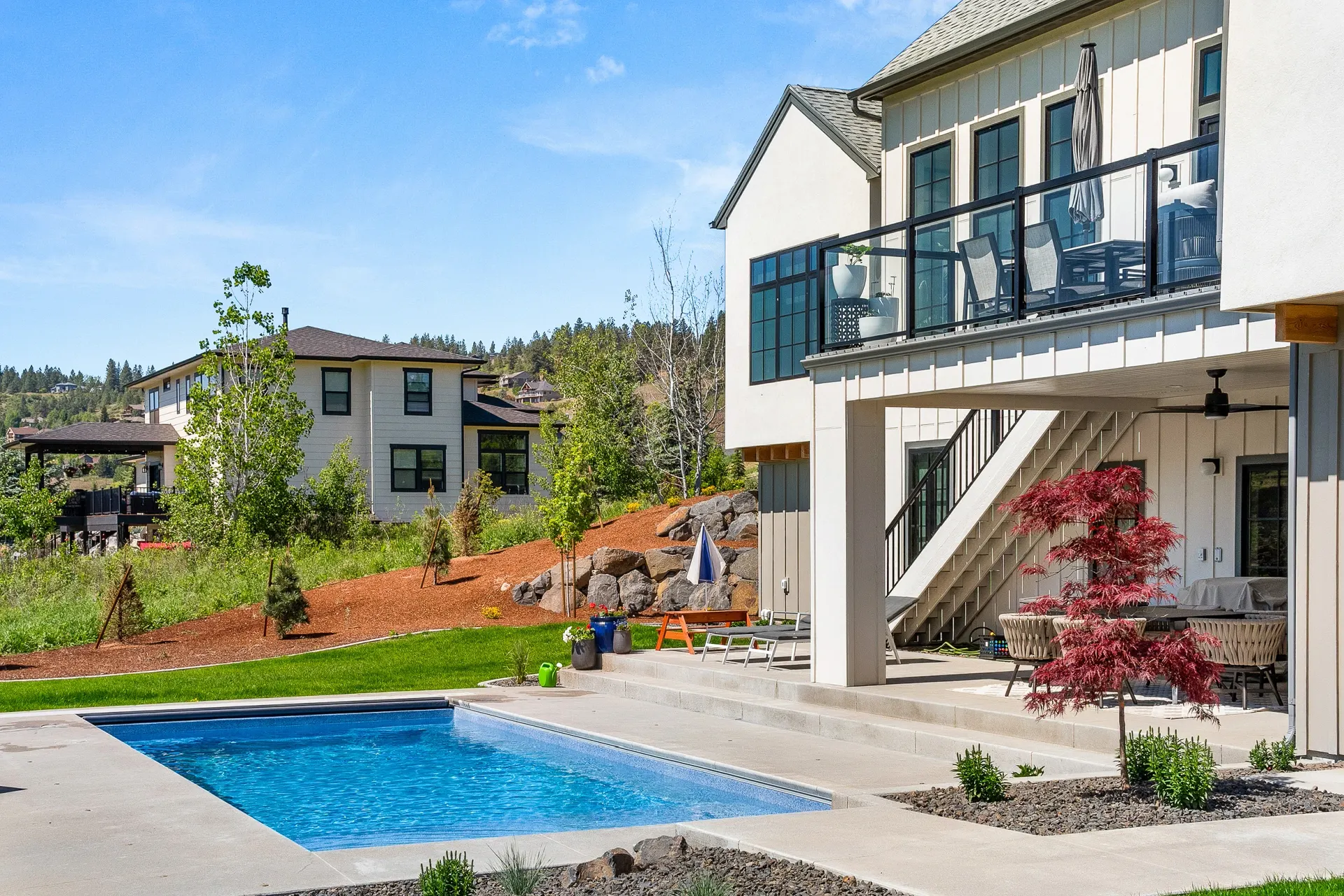 Modern Spokane home with a finished Waterscape fiberglass pool and clean concrete deck